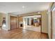 Open floorplan with hardwood floors, kitchen access, and wooden cabinets with attached desk at 4606 Sundance Trl, Indianapolis, IN 46239