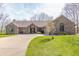 Inviting brick home featuring a curved driveway and pristine lawn, showcasing curb appeal at 5875 Annanhill Ct, Avon, IN 46123