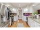 Well-lit kitchen with stainless steel appliances, granite countertops, brick backsplash, and hardwood floors at 5875 Annanhill Ct, Avon, IN 46123