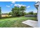 Large backyard with a concrete patio and a well-kept lawn surrounded by mature trees at 6103 Pebblebrooke Rd, Whitestown, IN 46075