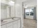 Bathroom boasts double sink vanity and a doorway view into the bedroom with natural light at 6103 Pebblebrooke Rd, Whitestown, IN 46075