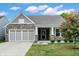 Charming single-Gathering home with a stone facade, neutral siding, manicured lawn, and a two-car garage at 6103 Pebblebrooke Rd, Whitestown, IN 46075