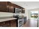 Modern kitchen featuring stainless steel appliances, dark cabinets, and a view to the outside at 6103 Pebblebrooke Rd, Whitestown, IN 46075