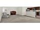 Spacious living room featuring neutral carpeting, an upright piano, and an open layout to the kitchen at 6103 Pebblebrooke Rd, Whitestown, IN 46075