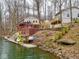 View of lakeside homes with decks, dock and watercraft nestled into a wooded landscape at 6141 Flamingo Dr, Nineveh, IN 46164