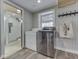 Laundry room with front load washer and dryer, peg coat rack, window, and walk-in shower in adjacent bathroom at 6141 Flamingo Dr, Nineveh, IN 46164