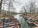 Lake view showcasing docks, boats, and waterfront homes surrounded by bare trees in winter at 6141 Flamingo Dr, Nineveh, IN 46164