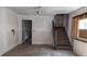 Unfinished room showing bare walls, hardwood floors, and a staircase, awaiting renovation at 621 N Euclid Ave, Indianapolis, IN 46201