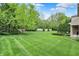 Lush backyard featuring a manicured lawn, mature trees, and neatly trimmed hedges at 6430 Meridian Pkwy # Apt A, Indianapolis, IN 46220