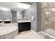 Luxurious bathroom featuring a soaking tub, dark wood vanity, and glass-enclosed shower at 6430 Meridian Pkwy # Apt A, Indianapolis, IN 46220