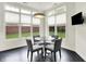 Breakfast nook with a glass table, four chairs, and large windows with window treatments at 6430 Meridian Pkwy # Apt A, Indianapolis, IN 46220