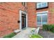 Close-up of brick townhome entryway with black door, stone accents, and decorative planters at 6430 Meridian Pkwy # Apt A, Indianapolis, IN 46220