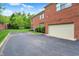 Exterior view featuring a brick facade, attached garage, and ample parking space at 6430 Meridian Pkwy # Apt A, Indianapolis, IN 46220