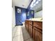 Bathroom with blue walls, double sink vanity, and tile floors at 6723 Balmoral Rd, Indianapolis, IN 46241