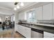 Well-lit kitchen showcasing white cabinets and stainless steel dishwasher overlooking dining area at 6826 Hague Rd, Indianapolis, IN 46256