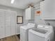 Bright laundry room featuring modern washer and dryer, storage cabinets, and convenient layout at 6826 Hague Rd, Indianapolis, IN 46256