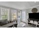 Sunlit living room with shiplap walls, a gray sofa, and a modern TV console, creating a relaxing atmosphere at 6826 Hague Rd, Indianapolis, IN 46256