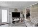 Cozy living room featuring shiplap walls, decorative TV console, and comfortable patterned armchair at 6826 Hague Rd, Indianapolis, IN 46256
