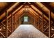 Attic with exposed wooden rafters and a window providing natural light and ventilation at 7131 Topp Creek Ct, Indianapolis, IN 46214