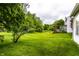 Spacious back yard featuring lush lawn and a charming red pergola at 7131 Topp Creek Ct, Indianapolis, IN 46214