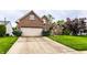 Front exterior showcasing brick facade, attached garage, and landscaped greenery with a concrete driveway at 7131 Topp Creek Ct, Indianapolis, IN 46214