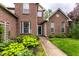 Detailed view of the front entrance with lush hosta landscaping and a brick facade at 7131 Topp Creek Ct, Indianapolis, IN 46214