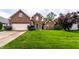 Beautiful two-story brick home featuring an attached garage and a lush green front lawn at 7131 Topp Creek Ct, Indianapolis, IN 46214