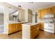 Bright kitchen featuring white countertops, wood cabinetry, island, and modern appliances at 7131 Topp Creek Ct, Indianapolis, IN 46214