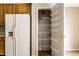 Kitchen features a pantry with wire shelving for efficient food storage next to a white refrigerator at 7131 Topp Creek Ct, Indianapolis, IN 46214