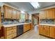 Well-lit kitchen with abundant wooden cabinets, stone backsplash, and laminate floors at 7180 W Sacramento Dr, Greenfield, IN 46140