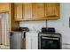 Laundry room with modern washer and dryer beneath wooden cabinets and utility sink at 7180 W Sacramento Dr, Greenfield, IN 46140