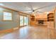 Spacious living room with a brick fireplace, built-in shelves, and sliding door to the backyard at 7180 W Sacramento Dr, Greenfield, IN 46140