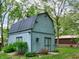 Well-kept outbuilding featuring painted siding and shingled roof in treed backyard at 7180 W Sacramento Dr, Greenfield, IN 46140