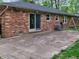 Back of brick home featuring a patio with a swing set, and an AC unit at 7180 W Sacramento Dr, Greenfield, IN 46140