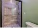 Glass enclosed shower with tile surround, rainfall showerhead, and decorative mosaic at 7180 W Sacramento Dr, Greenfield, IN 46140