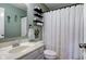 Bathroom boasts decorative shower curtain, black storage shelves, with a nice sink and mirror at 7634 Pennycroft Dr, Indianapolis, IN 46236