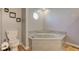 Bathroom featuring a toilet and soaking tub with light gray decor at 7634 Pennycroft Dr, Indianapolis, IN 46236
