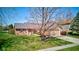 Ranch home with brick facade and blooming tree in a well-manicured lawn at 7634 Pennycroft Dr, Indianapolis, IN 46236