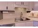 Close-up of the kitchen sink with stainless steel faucet and neutral countertops at 7634 Pennycroft Dr, Indianapolis, IN 46236