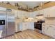 Well-lit kitchen with stainless steel appliances, light wood floor, and decorative accents on high shelf at 7634 Pennycroft Dr, Indianapolis, IN 46236
