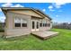 Backyard view of the home with a small wood deck and beige siding, perfect for outdoor enjoyment at 7702 Dornock Dr, Indianapolis, IN 46237