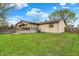 View of the home's backyard featuring lawn, wooden deck, and view of the rear of the home at 7702 Dornock Dr, Indianapolis, IN 46237
