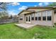 Backyard view featuring the deck and enclosed sunroom at 7702 Dornock Dr, Indianapolis, IN 46237