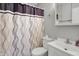 Cozy bathroom featuring a toilet, sink, vanity, mirror, and purple decorative shower curtain at 7702 Dornock Dr, Indianapolis, IN 46237