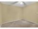 Simple carpeted bedroom with a ceiling fan, electrical outlets, and neutral wall paint at 7702 Dornock Dr, Indianapolis, IN 46237