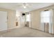 Spacious bedroom with ensuite bathroom and two windows, illuminated by a central ceiling fan at 7702 Dornock Dr, Indianapolis, IN 46237