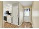 Inviting entryway with wood floors leading to a bright kitchen with white cabinets at 7702 Dornock Dr, Indianapolis, IN 46237