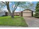 Charming ranch home with a two-car garage and mature tree in the front yard at 7702 Dornock Dr, Indianapolis, IN 46237