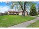 Ranch-style home with well-maintained lawn, mature trees, and attached two-car garage at 7702 Dornock Dr, Indianapolis, IN 46237
