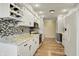 Bright kitchen featuring white cabinets, granite countertops, tile backsplash and wine rack at 7702 Dornock Dr, Indianapolis, IN 46237